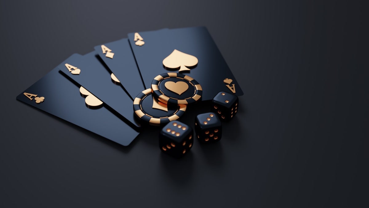 Black playing cards, chips and dice arranged on a dark surface.