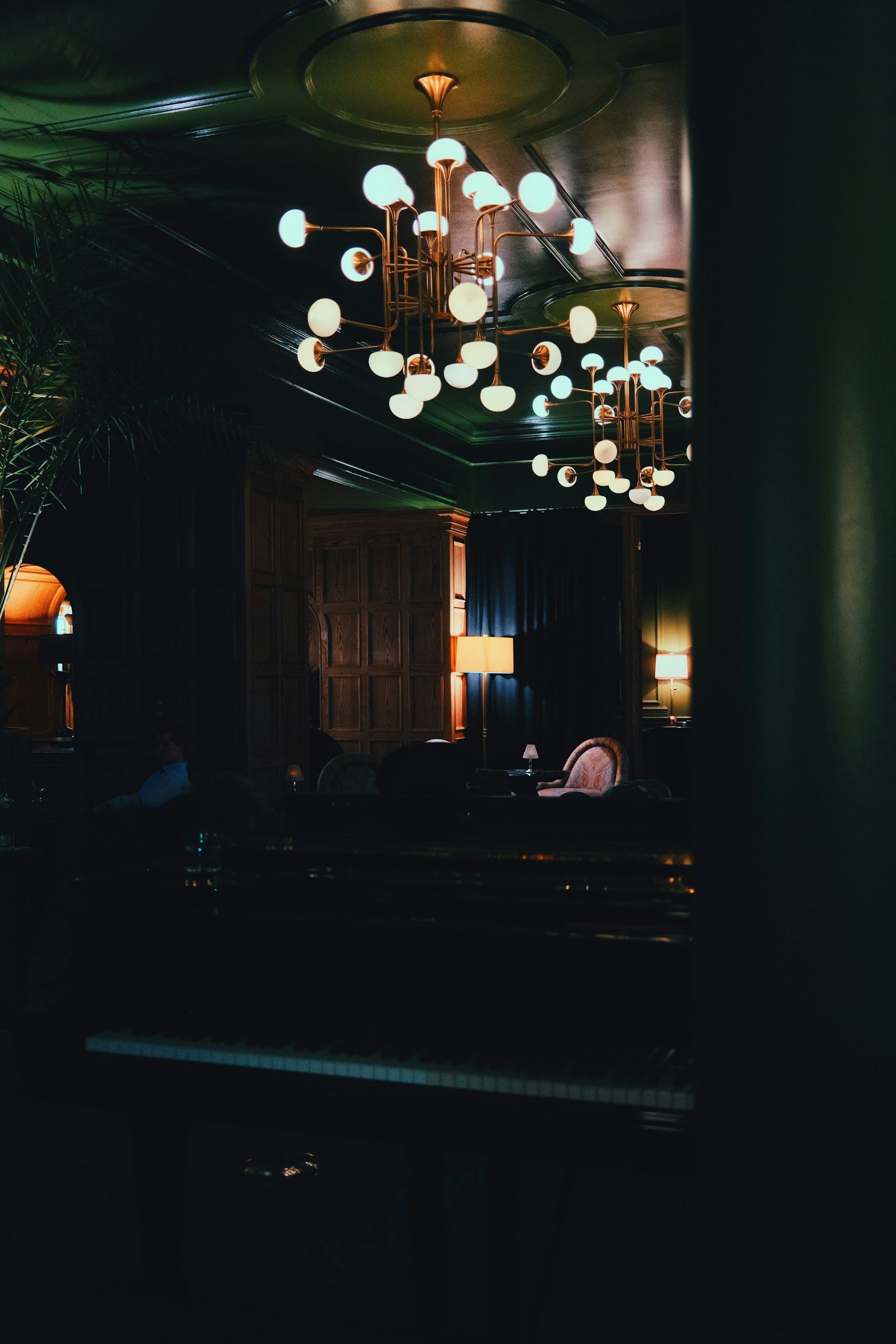 A quiet, wood-panelled private room lit by lamps and a low chandelier.